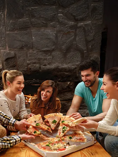 Vier Personen die Pizza essen